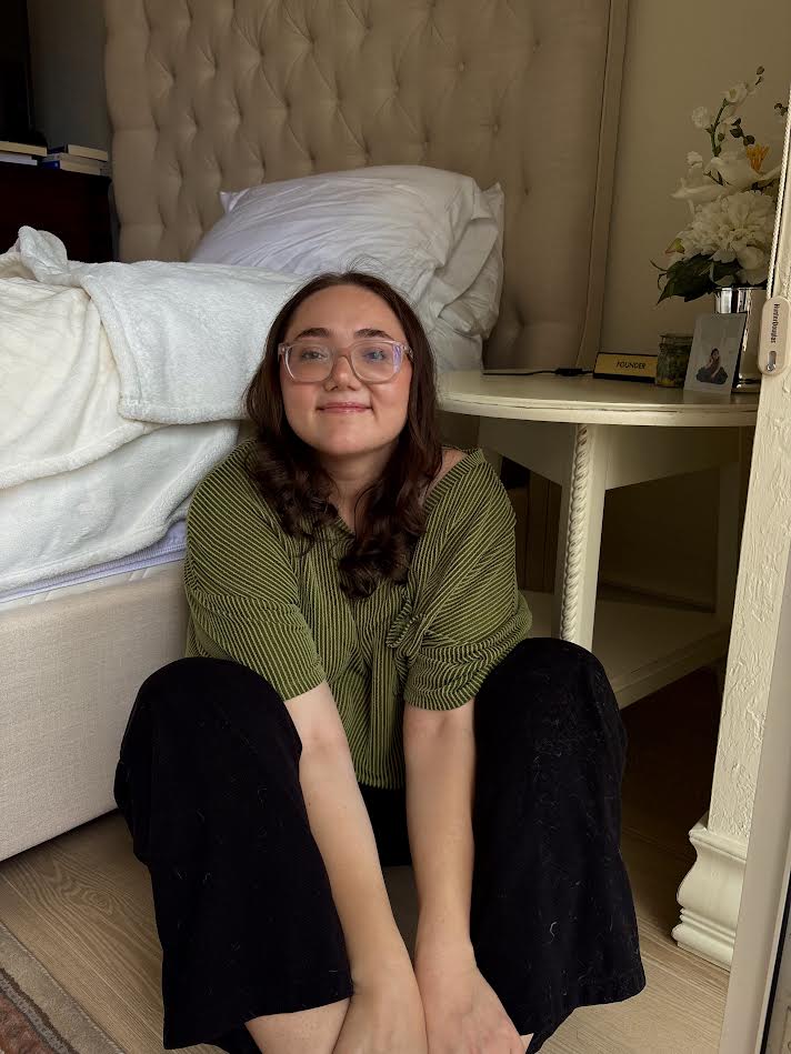 Lauren Grace Zemel smiling and seated on the floor, wearing a green striped shirt, author of the Gentle Strength blog